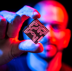 A male person holding up a microchip